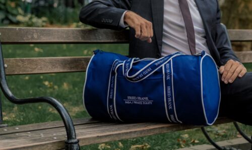 BankerBags Brand Image - Man sitting on bench with blue duffel bag