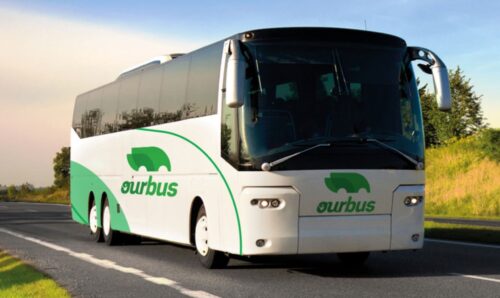 OurBus Brand Image - Green and White Bus driving on road